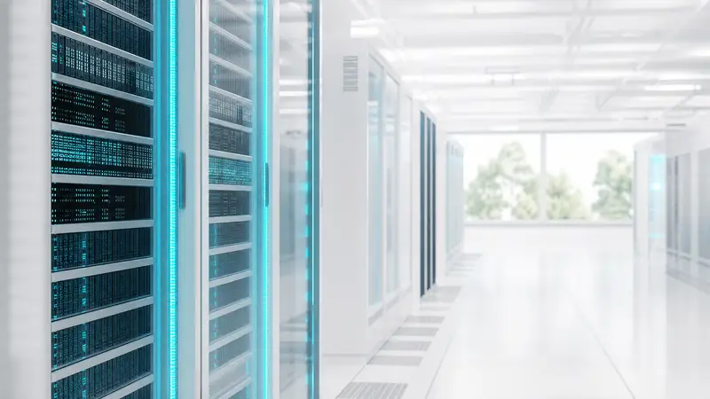 Rows of high-tech server racks with cyan lighting in a bright data center.